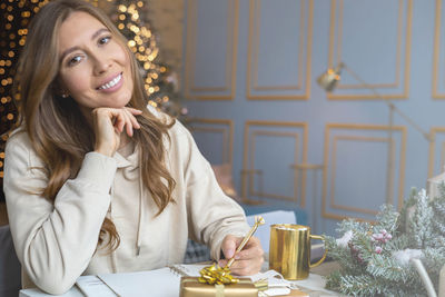 Portrait of young woman sitting at home