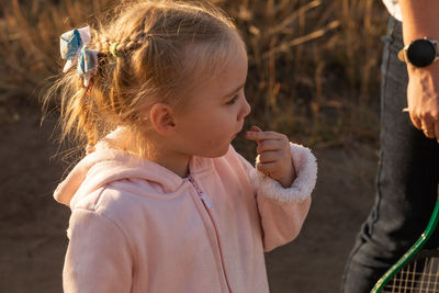 Little girl with saliva and dirty hands play outside in forest out in nature adventure