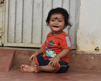 Portrait of cute boy sitting outdoors