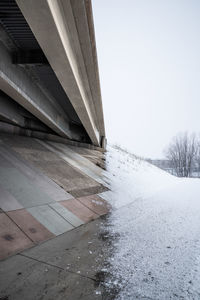 Bridge over road against sky in winter