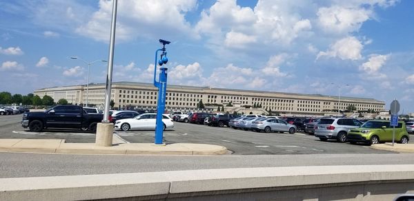 Vehicles on road against sky in city