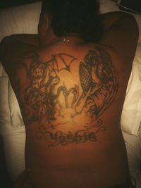 Rear view of shirtless woman with tattoo