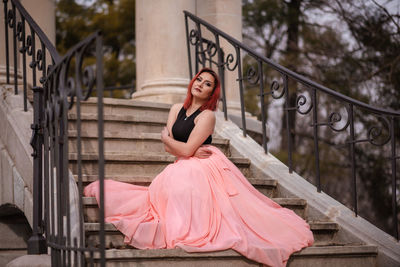 Full length portrait of woman sitting outdoors