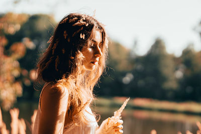 Portrait of a young woman wearing  flowers in hair outdoors