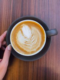 Person holding coffee cup on table