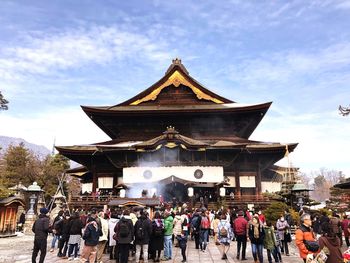 Group of people in traditional building against sky