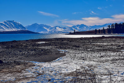 Scenic view of snowcapped mountains against blue sky