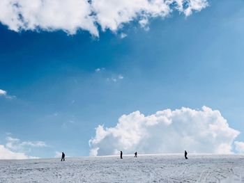 People on snowy landscape against sky