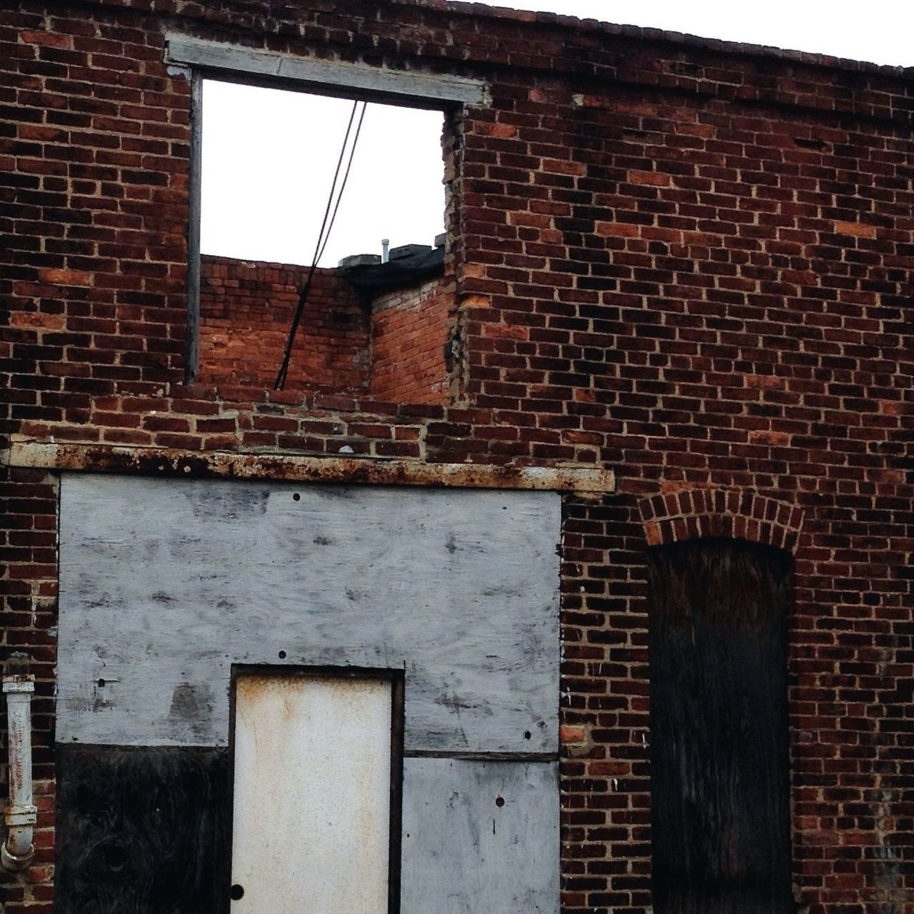 architecture, building exterior, built structure, window, brick wall, house, residential structure, wall - building feature, old, residential building, weathered, low angle view, wall, building, day, abandoned, outdoors, exterior, damaged, door