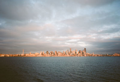 Buildings in city against cloudy sky