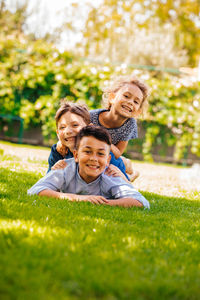 Portrait of happy boy smiling while sitting on grass