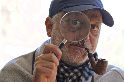 Close-up portrait of man holding eyeglasses