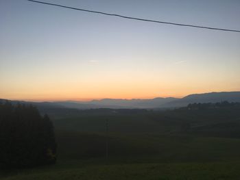 Scenic view of field against clear sky at sunset