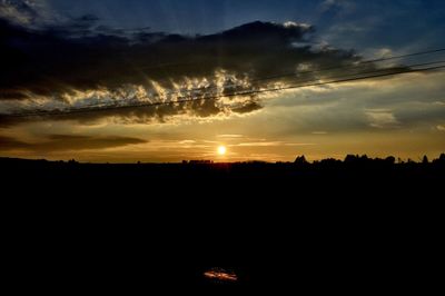 Scenic view of silhouette landscape against dramatic sky during sunset