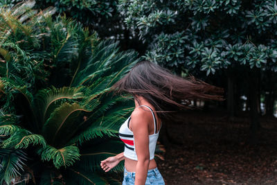 Rear view of woman standing by tree