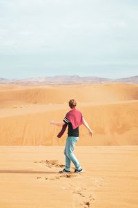 Full length of woman on sand dune