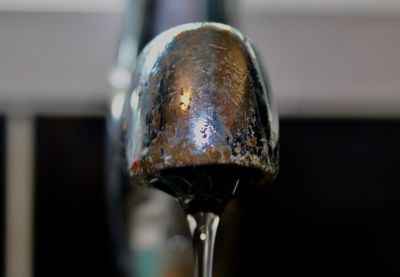 Close-up of water faucet against wall