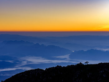 Scenic view of silhouette mountains against sky at sunset