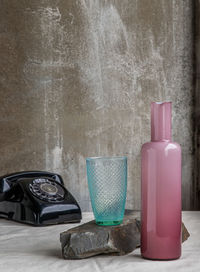 Close-up of bottles on table against wall