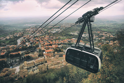 Overhead cable car in city against sky