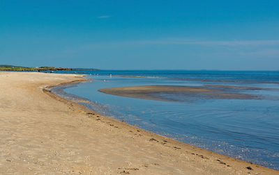 Scenic view of beach against clear blue sky