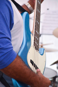 Midsection of man playing guitar