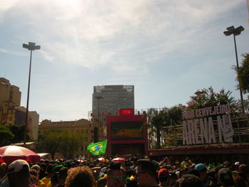 People on street in city against sky