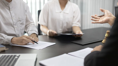 Midsection of business colleagues working on table