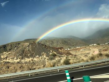 Scenic view of rainbow over mountains against sky