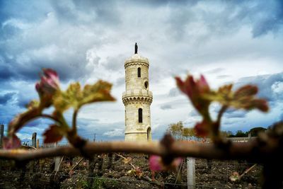 Tower on field against cloudy sky