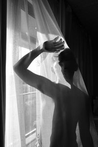 Shadow of woman holding glass window