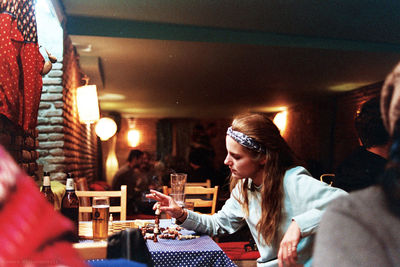 Young woman sitting in illuminated room