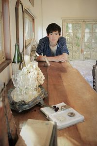 Portrait of teenage boy sitting on table at home