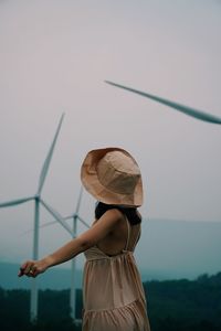 Rear view of woman standing against sky