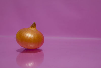 Close-up of fruits on table against pink background