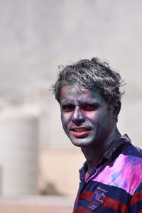 Close-up portrait of man covered in powder paint during holi