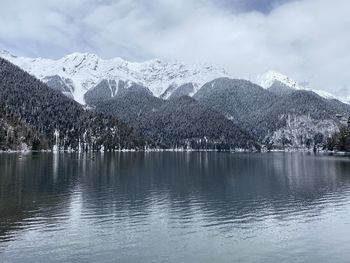 Scenic view of lake by snowcapped mountains against sky