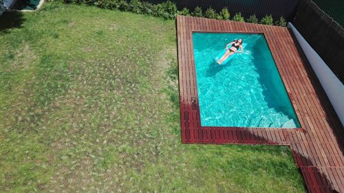 High angle view of woman relaxing in swimming pool