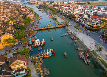 High angle view of crowd by river against buildings in city