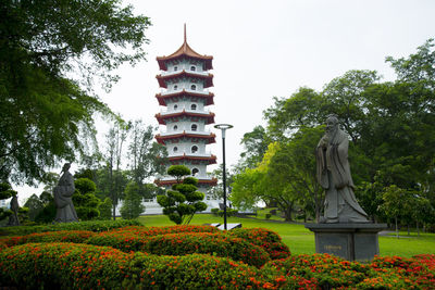 Statue of flowering plants against trees