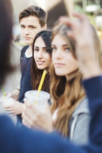 Teenagers looking at friend outdoors