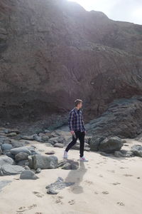 Men walking rocks beach