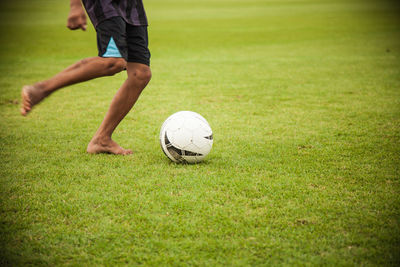 Low section of man playing soccer on field