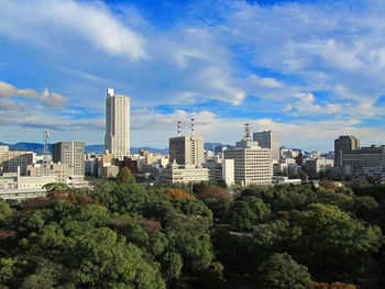 Trees and buildings in city of hiroshima  against sky