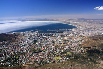 Aerial view of city by sea against sky