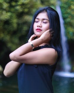 Portrait of beautiful young woman standing outdoors