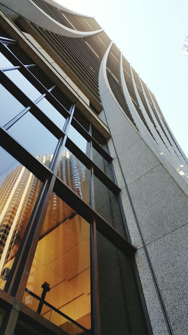 architecture, low angle view, built structure, building exterior, modern, tall - high, office building, clear sky, tower, building, skyscraper, city, glass - material, sky, tall, day, architectural feature, outdoors, sunlight, window