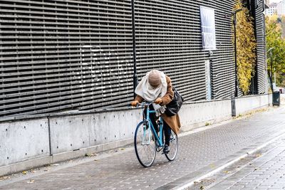 Woman riding bicycle on city street