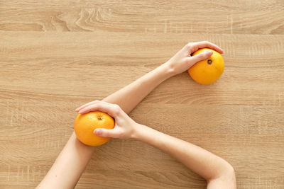 Juicy lemon in hands on wooden background tomato-ˈmätō,təˈmātō Перекл