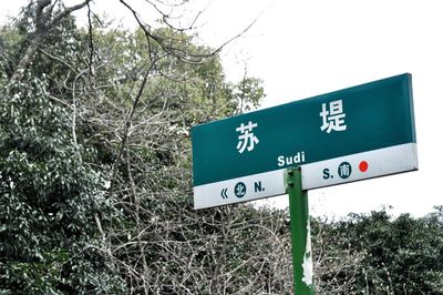 Close-up of road sign against sky